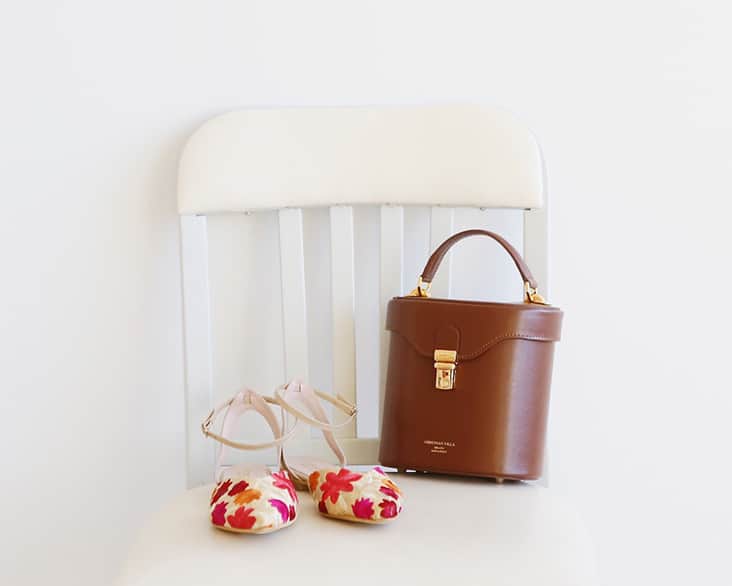 白い椅子の上に 茶色バッグ 花柄シューズ