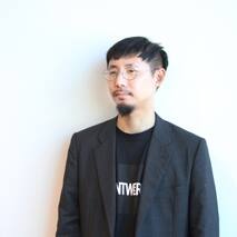 バイヤー小林顔写真 黒ジャケット 黒ロゴT着用